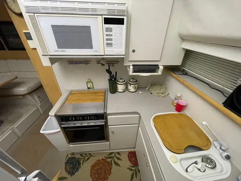 Slide: The Image of 1995 Carver 440 Aft Cabin Motor Yacht kitchen with microwave, stove, and sink. - 37