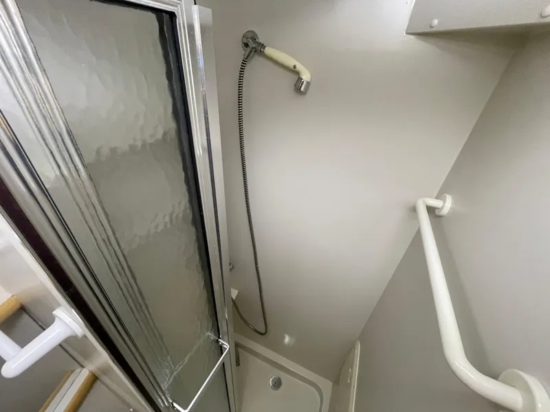 Slide: The Image of Shower area in 1995 Carver 440 Aft Cabin Motor Yacht, featuring sliding door and handheld showerhead. - 41