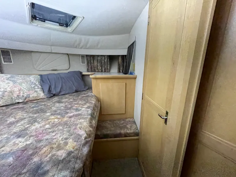 Slide: The Image of 1995 Carver 440 Aft Cabin Motor Yacht bedroom with bed, wooden cabinetry, and window. - 44