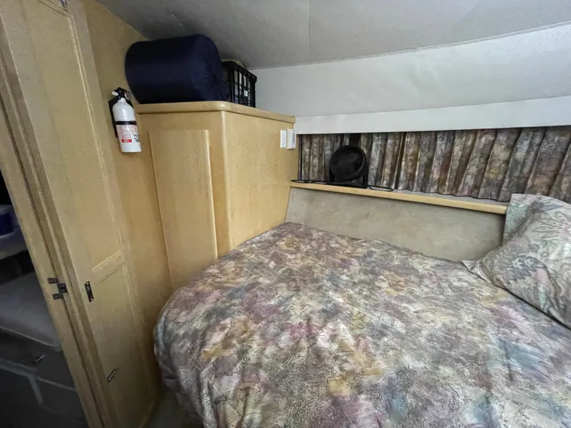 Slide: The Image of 1995 Carver 440 Aft Cabin Motor Yacht bedroom with bed, storage, and fire extinguisher. - 45