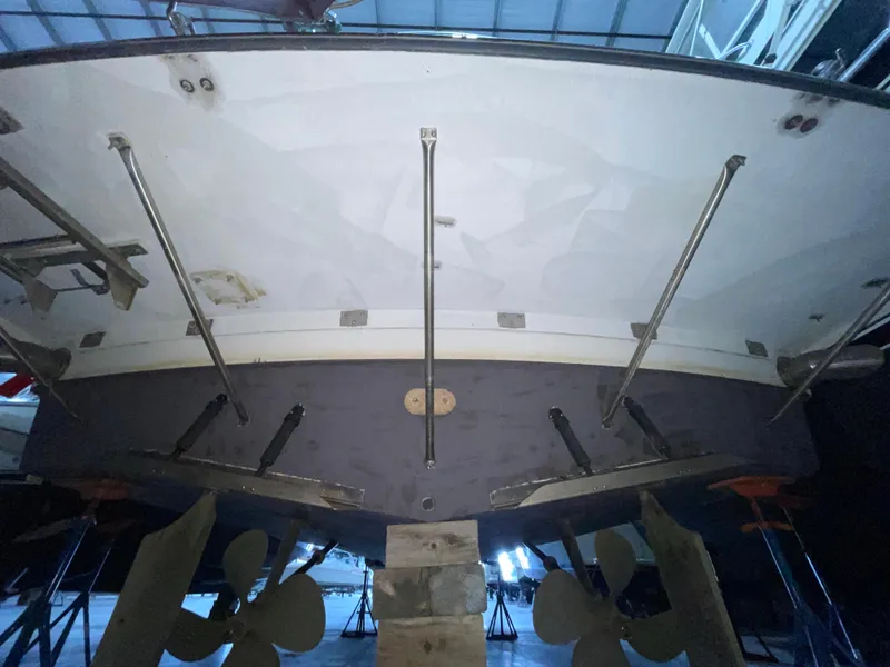 Slide: The Image of 1995 Carver 440 Aft Cabin Motor Yacht underbody with propellers and supports in a boatyard. - 5