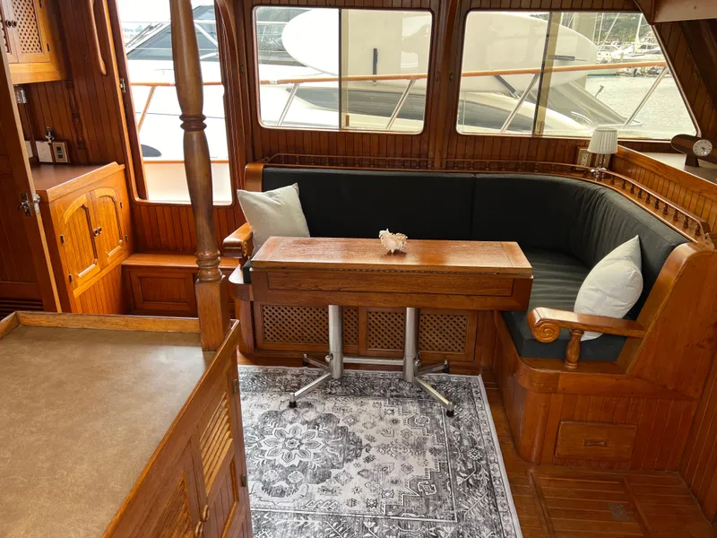 Slide: The Image of 1984 DeFever 41 Trawler interior with wooden furnishings, cozy seating, and nautical decor. - 13