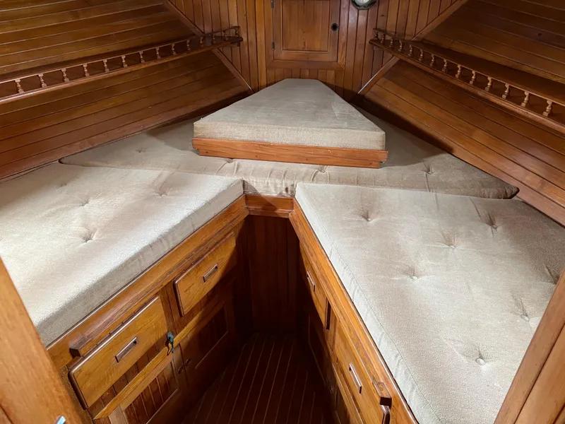 Slide: The Image of 1984 DeFever 41 Trawler cabin with wooden interior and beige cushioned seating. - 16
