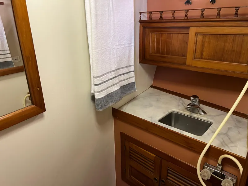Slide: The Image of 1984 DeFever 41 Trawler bathroom with wooden cabinets and marble countertop. - 17