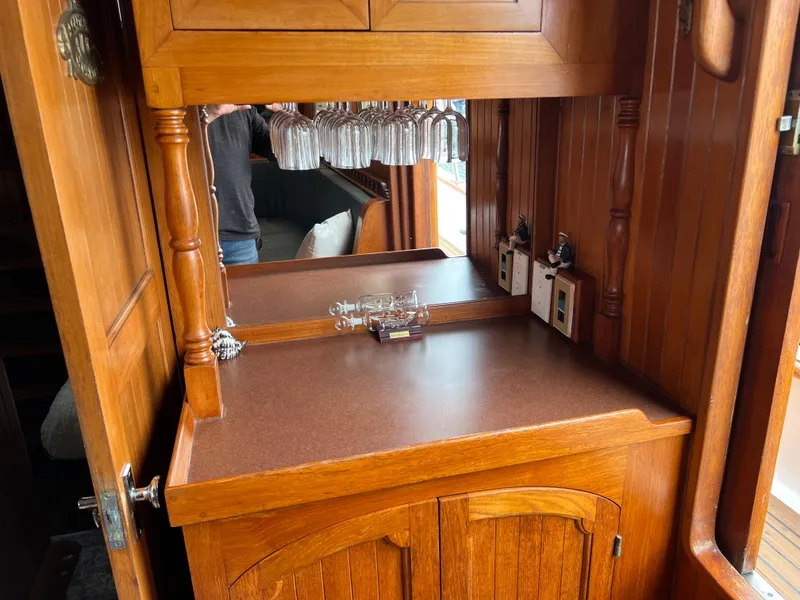 Slide: The Image of 1984 DeFever 41 Trawler interior with wooden cabinetry and glassware storage. - 18