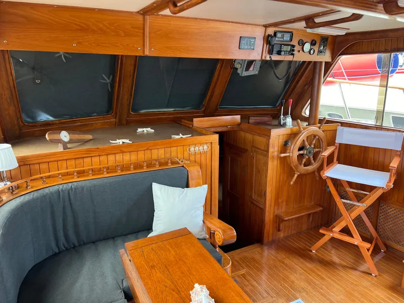 Slide: The Image of 1984 DeFever 41 Trawler interior with wooden helm, seating, and nautical decor. - 20