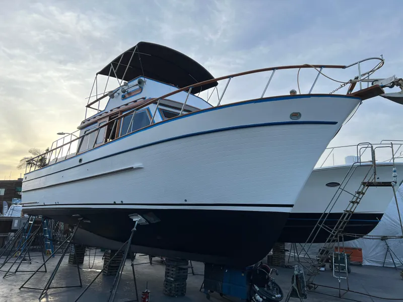 Slide: The Image of 1984 DeFever 41 Trawler boat on dry dock, side view, with clear sky background. - 21
