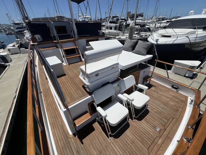 Slide: The Image of 1984 DeFever 41 Trawler with wooden deck and seating, docked at a marina. - 9