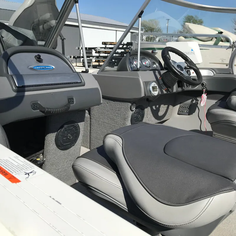 Slide: The Image of Interior of a 2016 Crestliner 1850 Super Hawk boat, featuring steering wheel and seating. - 11
