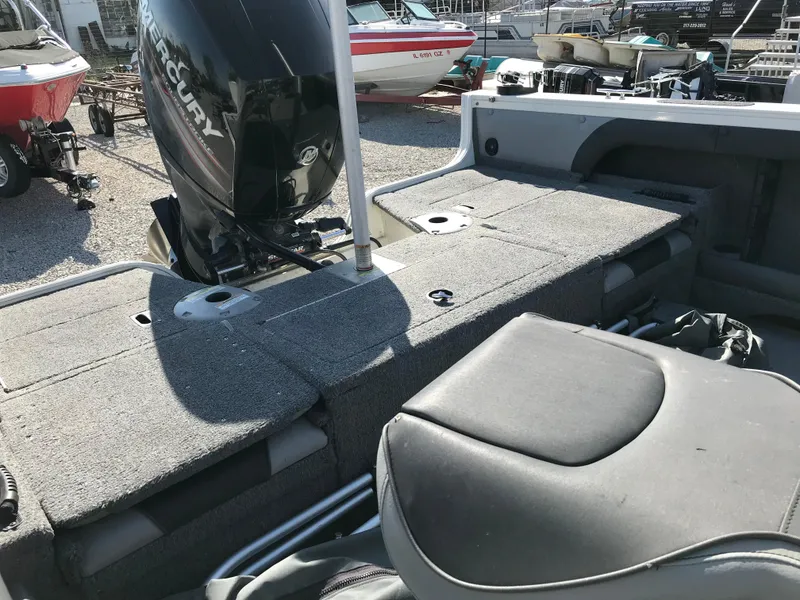 Slide: The Image of 2016 Crestliner 1850 Super Hawk boat interior with Mercury engine, featuring seating and storage. - 15