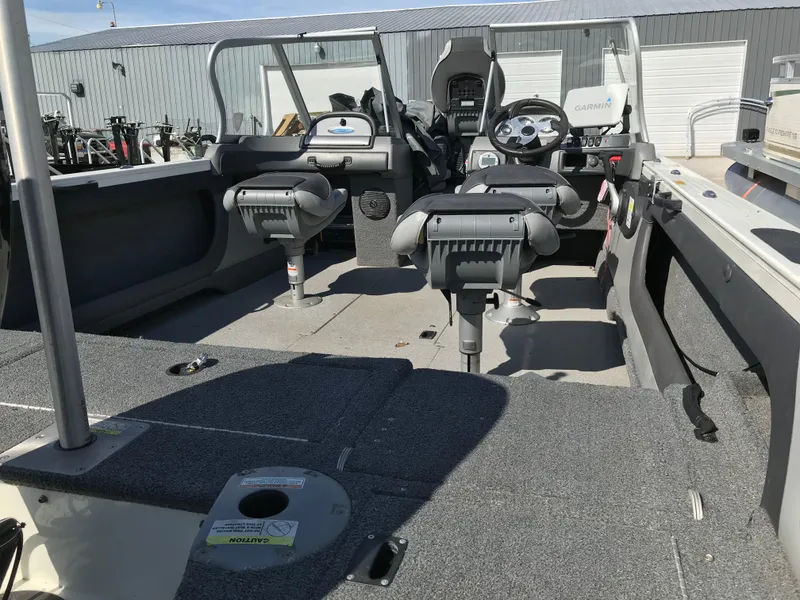Slide: The Image of 2016 Crestliner 1850 Super Hawk interior with seating and control panel, parked outdoors. - 16