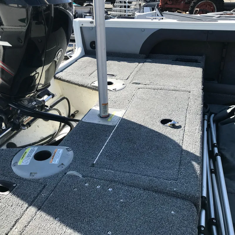 Slide: The Image of 2016 Crestliner 1850 Super Hawk boat interior with motor and carpeted deck. - 9