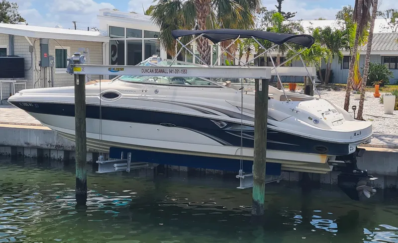 The Image of 2004 Sea Ray 270 Sundeck boat docked on a lift by waterfront property. - 0