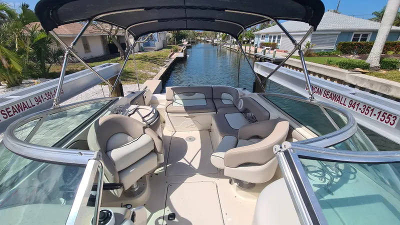 Slide: The Image of 2004 Sea Ray 270 Sundeck boat with spacious seating, docked in a canal under sunny skies. - 14