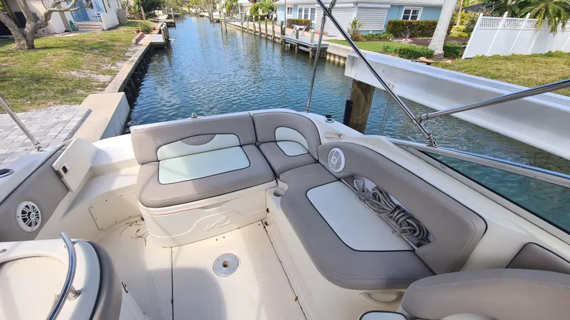 Slide: The Image of 2004 Sea Ray 270 Sundeck boat interior with cushioned seating by a canal. - 15