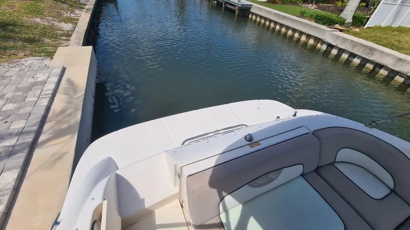 Slide: The Image of 2004 Sea Ray 270 Sundeck boat docked in a calm canal setting. - 16