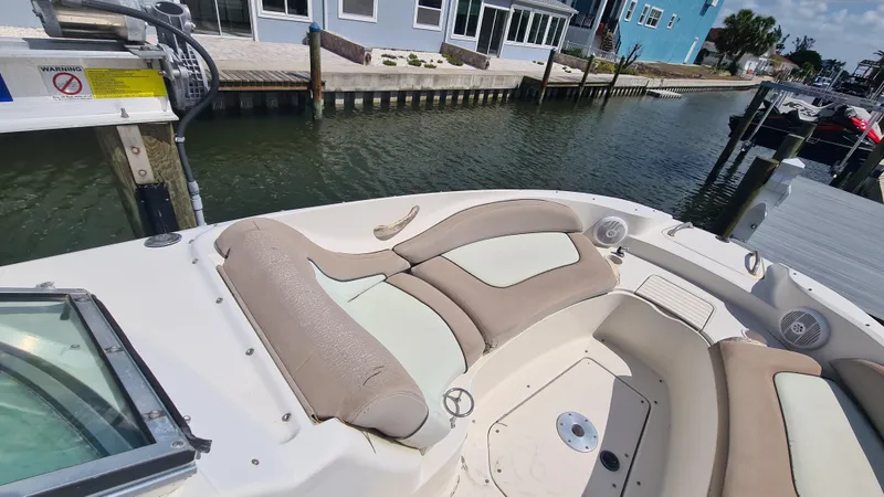Slide: The Image of 2004 Sea Ray 270 Sundeck boat interior with beige seating, docked by waterfront homes. - 4