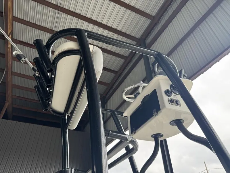 Slide: The Image of 2018 Mako Pro Skiff 19 CC Top Drive under a metal roof, showcasing steering console. - 12