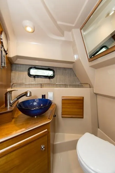 Slide: The Image of 2018 Ranger Tugs R27 OB boat bathroom with modern sink, mirror, and compact design. - 6