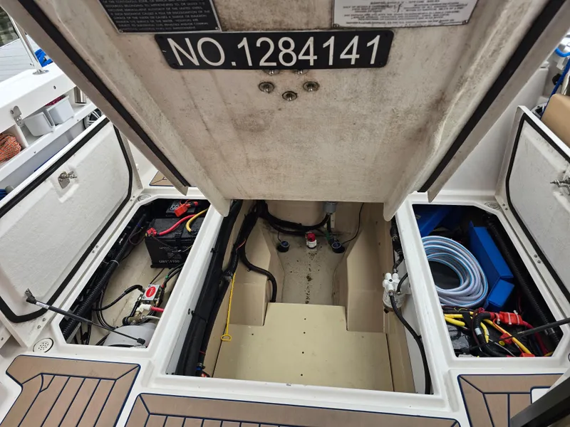 Slide: The Image of 2018 Ranger Tugs R27 OB engine compartment with storage and wiring visible. - 9