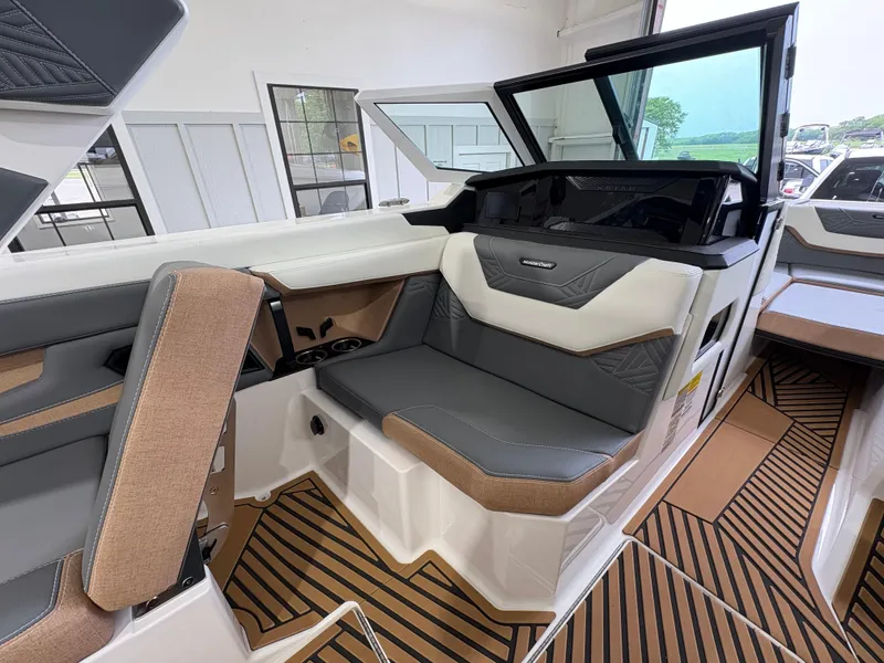 Slide: The Image of 2025 MasterCraft XStar 23 boat underside showing propeller and exhaust system in a showroom. - 23