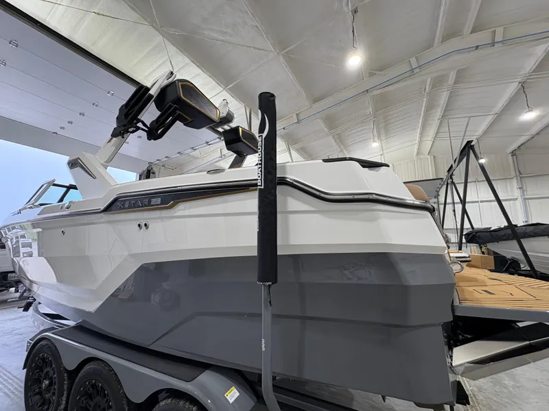 Slide: The Image of 2025 MasterCraft XStar 23 boat on a trailer in a showroom. - 3