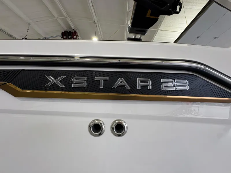 Slide: The Image of 2025 MasterCraft XStar 23 boat on trailer in spacious showroom. - 4