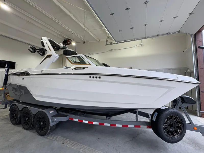 Slide: The Image of 2025 MasterCraft XStar 23 boat on trailer in indoor showroom. - 6