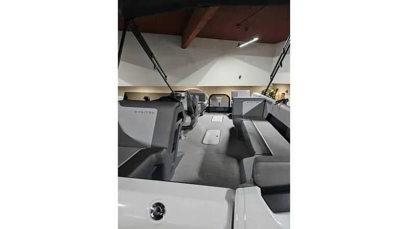 Slide: The Image of 2025 Manitou 20 CRUISE MAX boat interior with spacious seating and modern design. - 12
