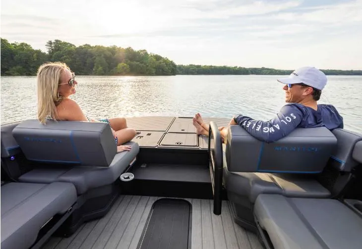 Slide: The Image of 2025 Manitou 20 CRUISE MAX pontoon boat on a serene lake, featuring a 150hp Rotax Stealth Motor. - 8