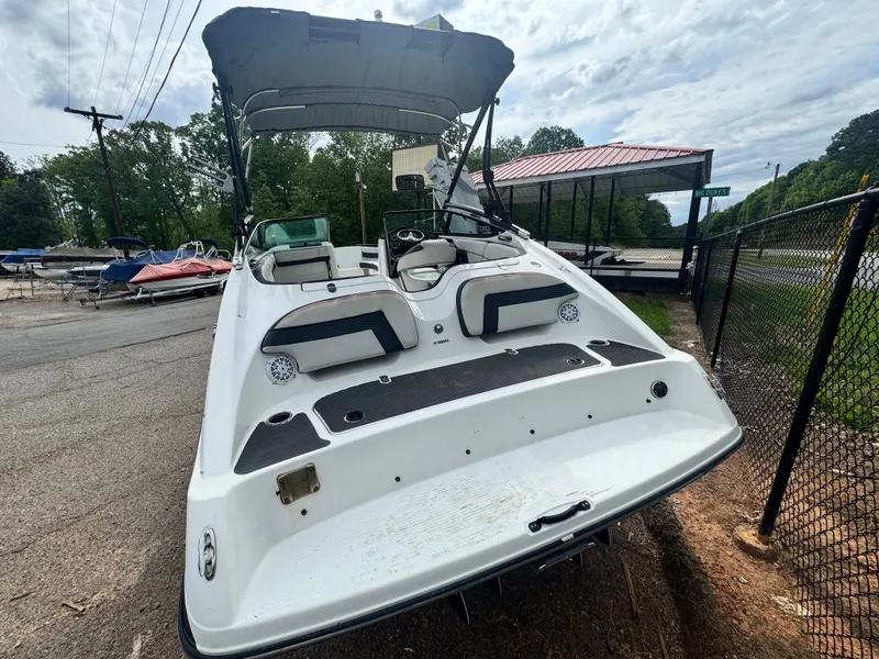 Slide: The Image of 2014 Yamaha Boats 212X with canopy, parked on a trailer, rear view. - 5