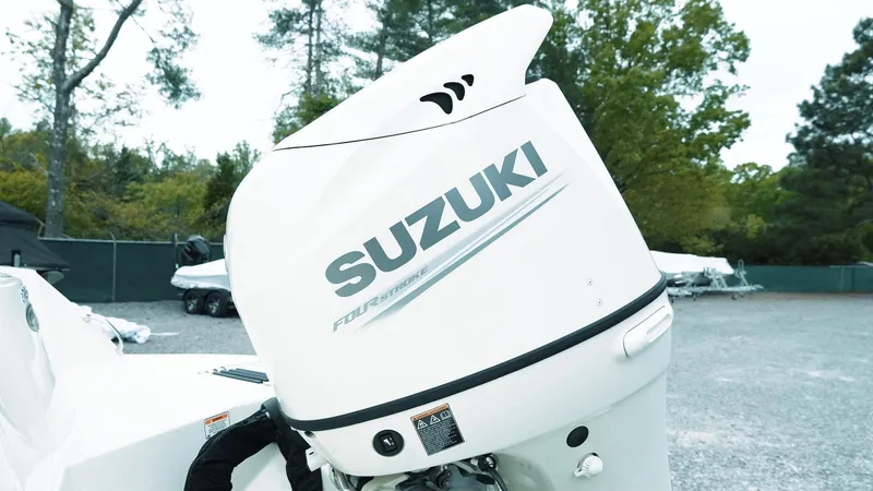 Slide: The Image of Suzuki outboard motor on a 2019 Stingray 206 CC boat, parked outdoors. - 4
