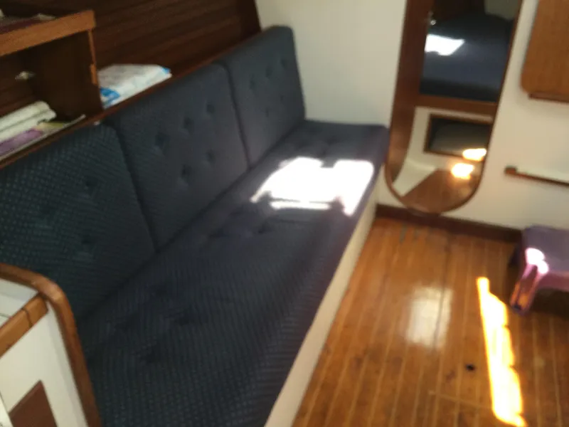 Slide: The Image of Interior of 1997 J Boats J/32 sailboat with blue cushioned seating and wooden flooring. - 26