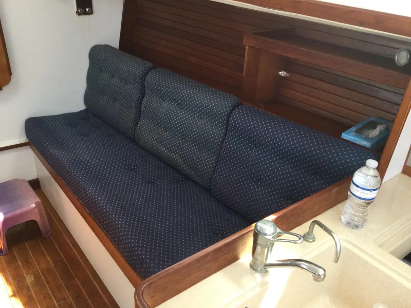 Slide: The Image of 1997 J Boats J/32 interior with blue cushioned seating and wooden accents. - 27