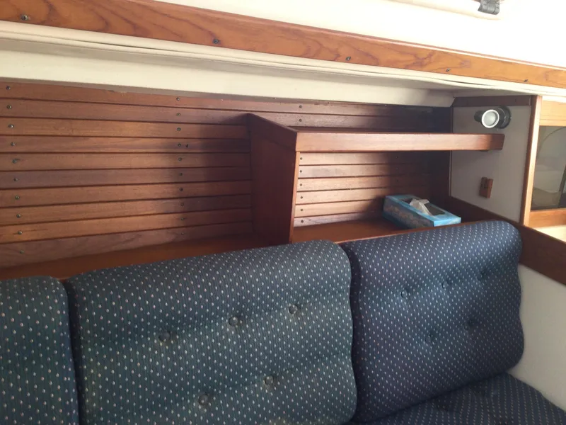 Slide: The Image of Interior of 1997 J Boats J/32 with wooden shelving and blue cushioned seating. - 36