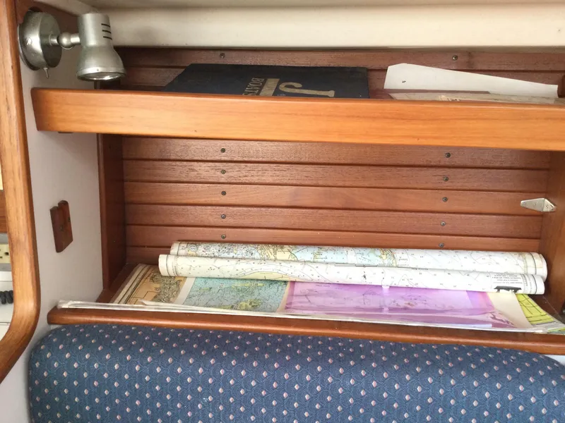 Slide: The Image of Wooden shelf with nautical charts and book inside a 1997 J Boats J/32 sailboat. - 37