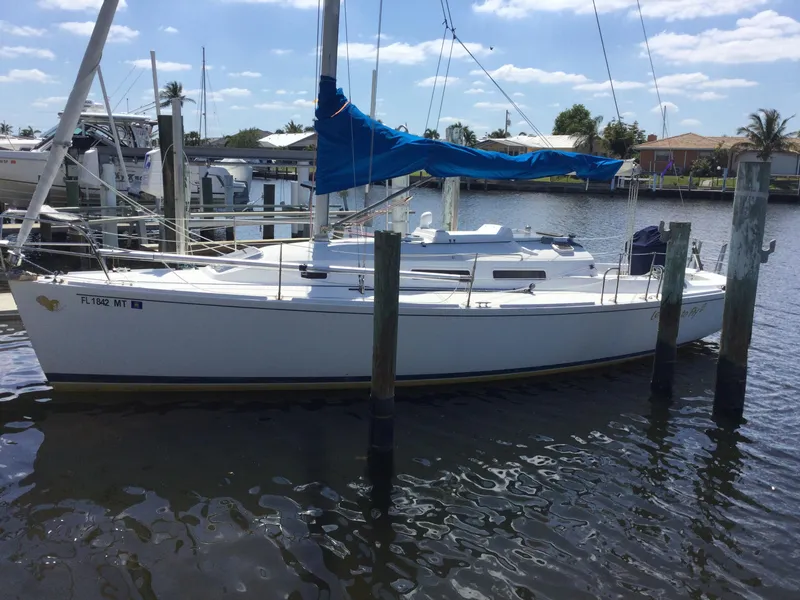 Slide: The Image of 1997 J Boats J/32 sailboat docked in a marina, featuring a blue sail cover. - 4