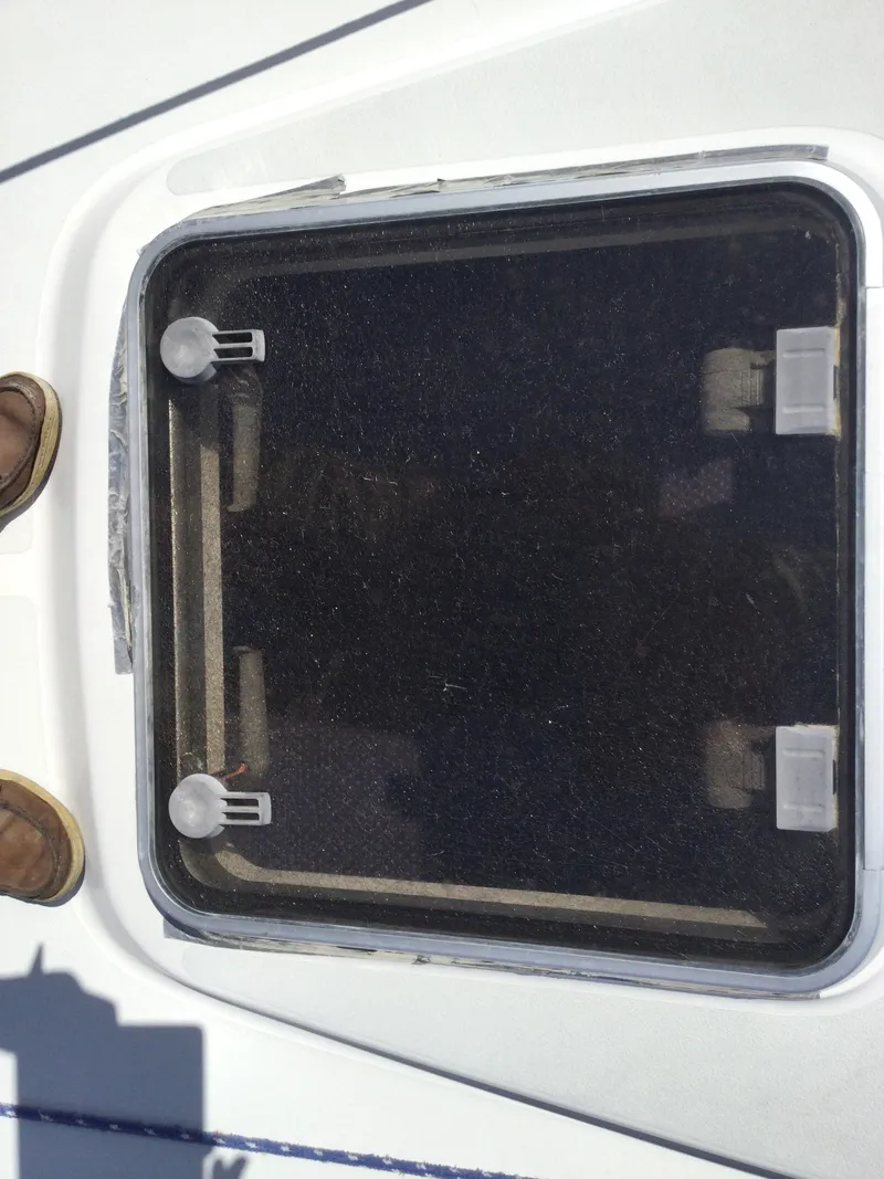 Slide: The Image of 1997 J Boats J/32 deck hatch with secure latches and visible footwear. - 45