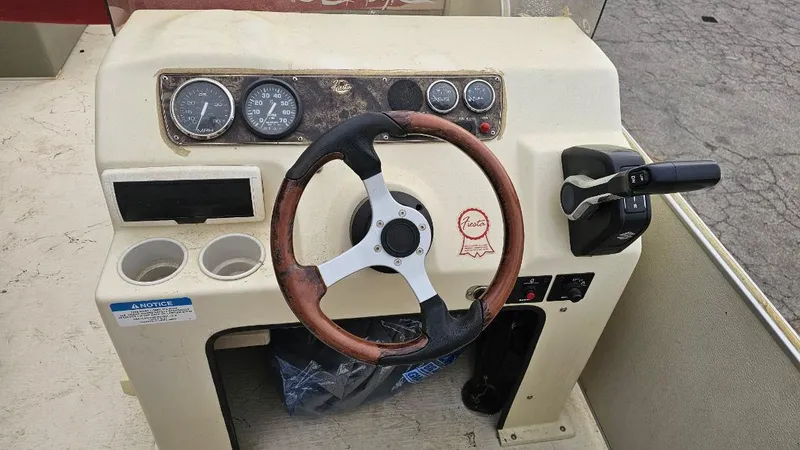 Slide: The Image of 2006 Fiesta 26' Fundeck L Sofa RE Deluxe boat dashboard with steering wheel and controls. - 2