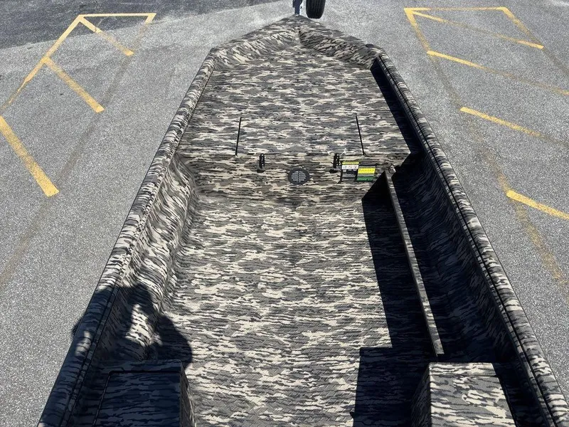 Slide: The Image of Camouflage-patterned Havoc RDBST 1553 boat, 2025 model, parked on asphalt with yellow lines. - 11