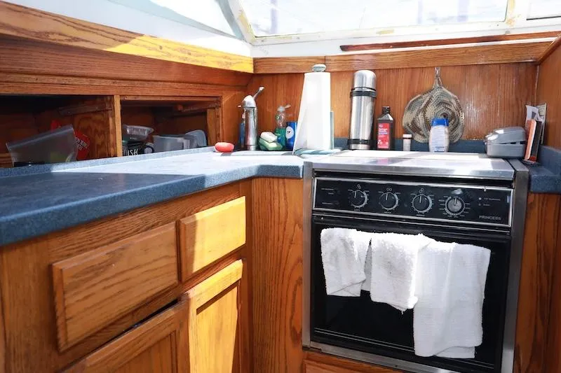 Slide: The Image of 1972 Trojan 36 yacht kitchen with wooden cabinets and modern appliances. - 15