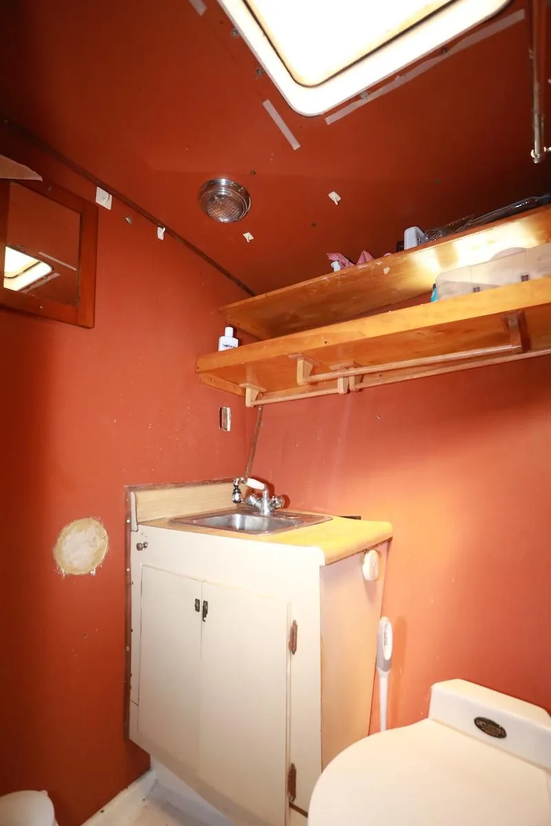 Slide: The Image of 1972 Trojan 36 boat bathroom with sink, cabinet, and shelf under skylight. - 20