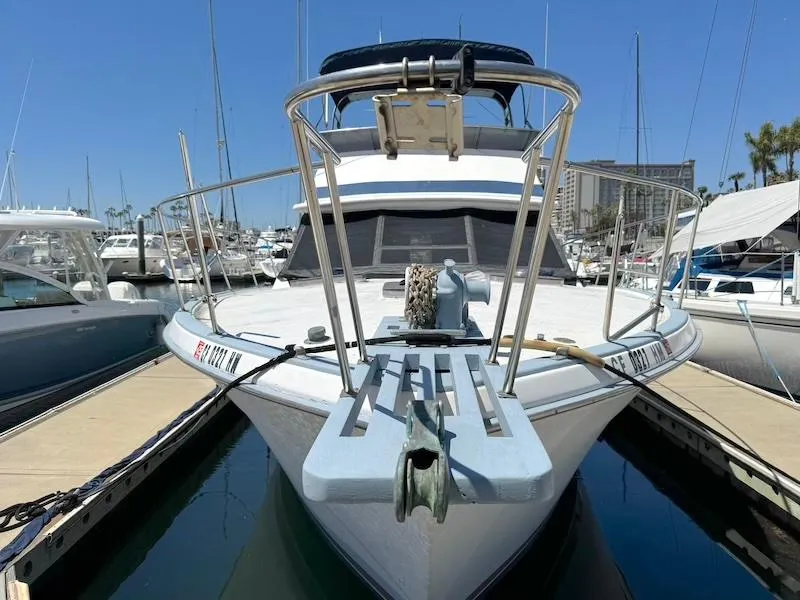 Slide: The Image of 1972 Trojan 36 boat docked at marina, front view with clear blue sky. - 4