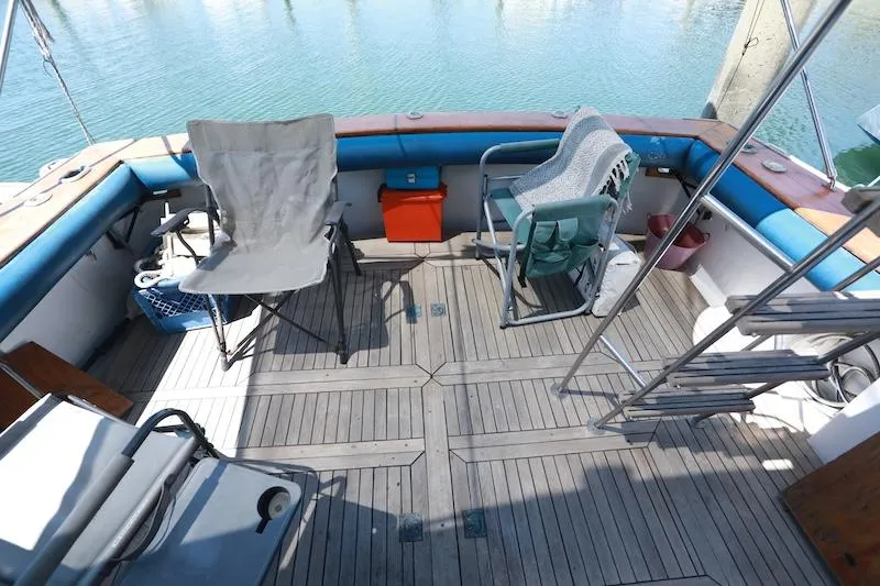 Slide: The Image of 1972 Trojan 36 boat deck with chairs and ladder, overlooking calm water. - 8