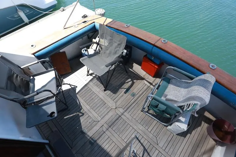Slide: The Image of 1972 Trojan 36 boat deck with chairs, wooden flooring, and water view. - 9