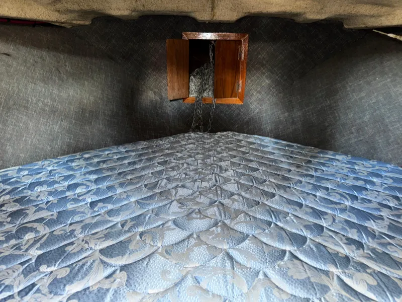 Slide: The Image of Interior of a 1974 Roberts 30' boat with a patterned mattress and wooden hatch. - 17