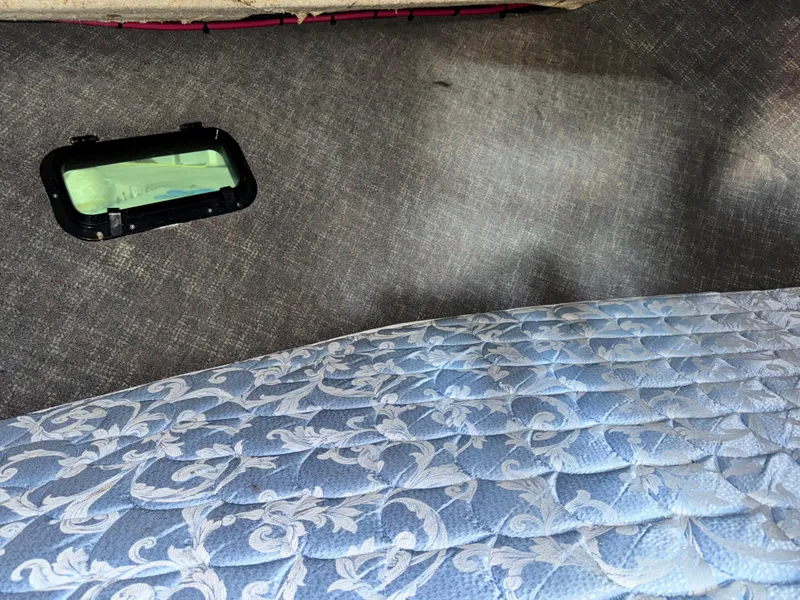 Slide: The Image of Interior of a 1974 Roberts 30' boat with patterned mattress and small window. - 18