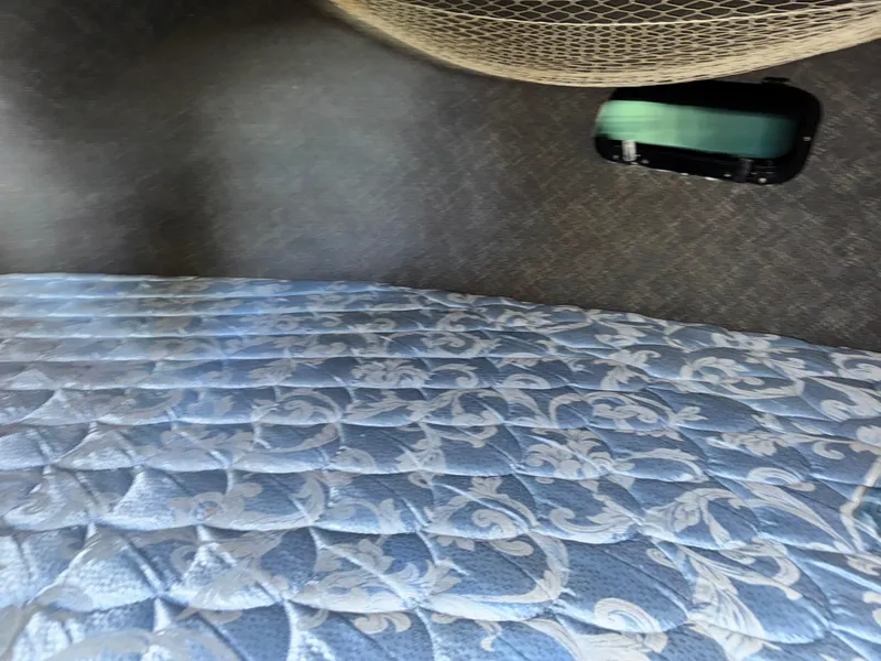 Slide: The Image of Interior of a 1974 Roberts 30' boat with a patterned mattress and netting. - 19