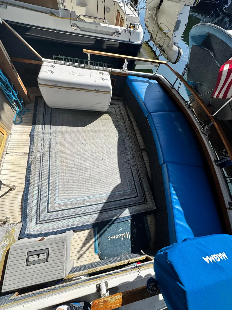 Slide: The Image of 1974 Roberts 30' boat deck with blue seating, cooler, and welcome mat. - 2