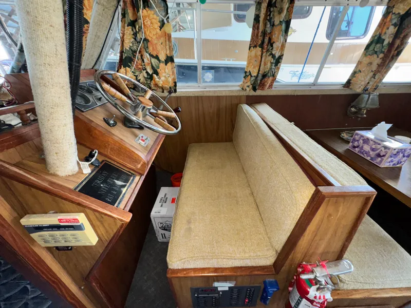 Slide: The Image of 1974 Roberts 30' boat interior with steering wheel, floral curtains, and beige seating. - 20